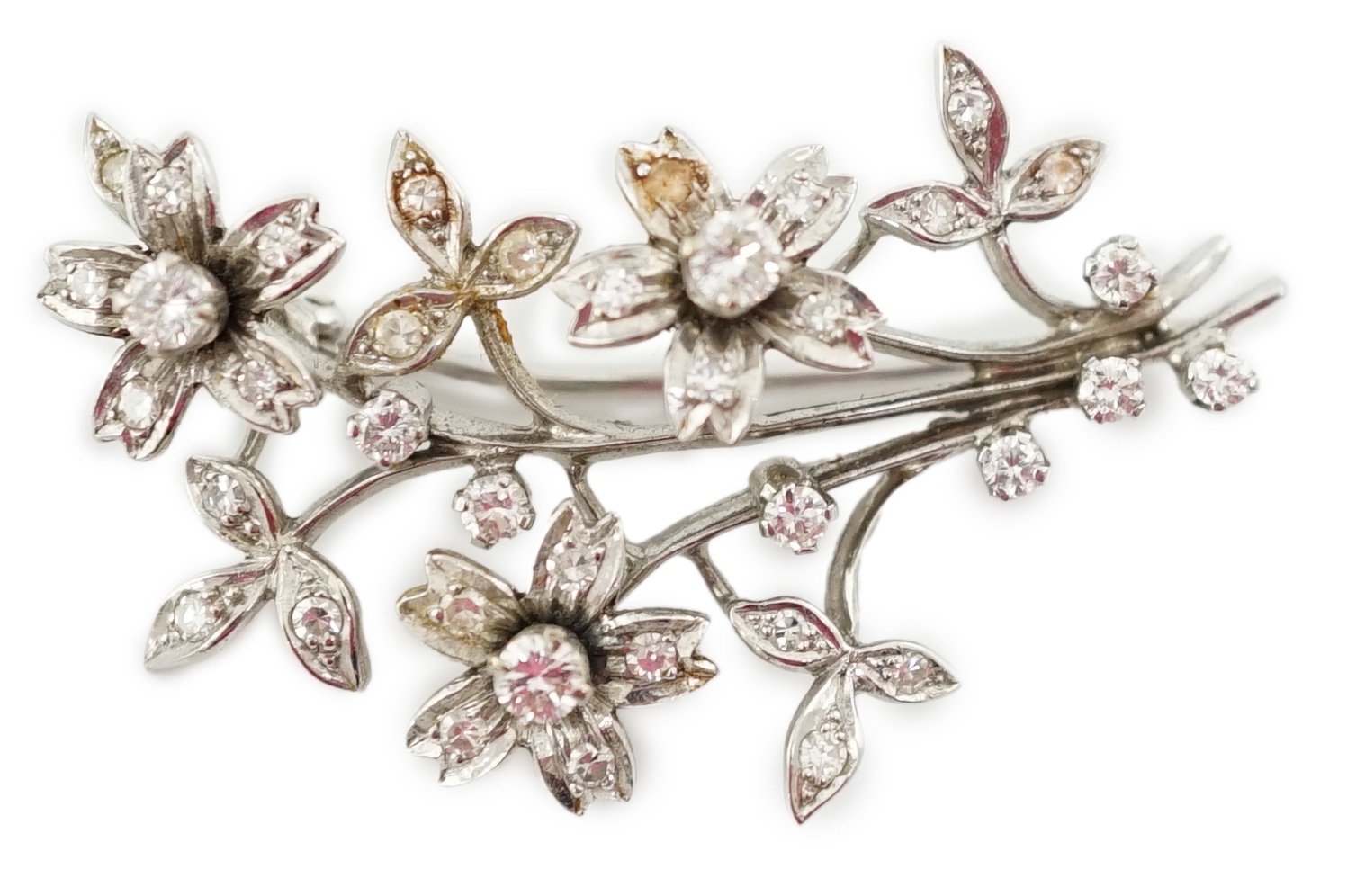 A 1960's 18ct white gold and diamond cluster set floral spray brooch
